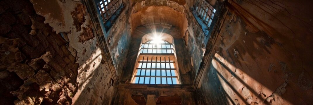 Light shines through a barred window in an abandoned building. AI.