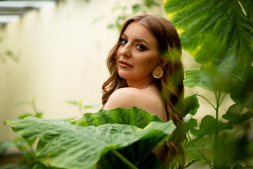 beautiful young sexy nude woman cover her body with palm leaf outdoors portrait