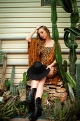 beautiful stylish young woman i in desert among the cacti, traveling in Africa on safari, exploring nature, sunny summer, traveler on
