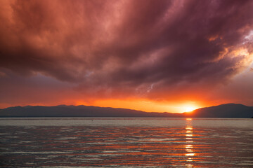 Beautiful bright sunset over the lake and Mountains.