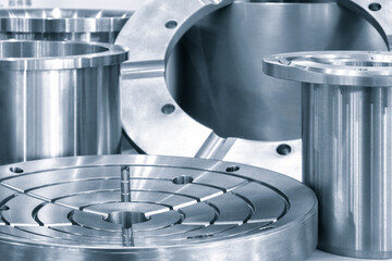 A collection of metal parts, including a round piece with a hole in the middle. Concept of precision and engineering, as the various parts are arranged in a neat and organized manner