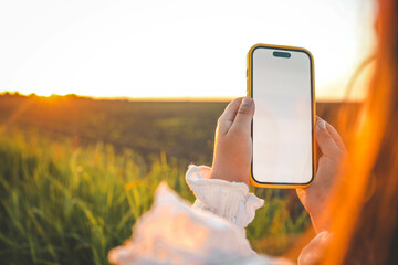 A girl takes a photo of a beautiful sunset