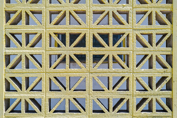 A decorative concrete block divider wall with a repeating geometric pattern