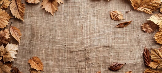 Fototapeta premium Brown Autumn Leaves on Tan Fabric and Background