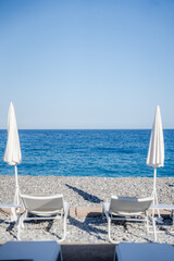 chairs and umbrella on the beach with a view on the sea