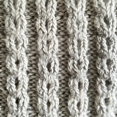 Close-up of cozy knitted soft beige fabric.