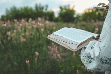 Open bible in hands close-up, concept of calmness and morning solitude