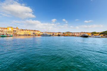 Sailboats and luxury yachts line the colorful marina filled with shops and seaside cafes in the town of Saint-Tropez, France, a popular resort town on the Mediterranean Cote d'Azur, French Riviera	