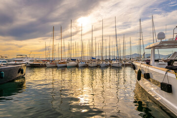Sunset view of sailboats and luxury yachts in the old port marina at the Mediterranean city of Saint-Tropez on the French Riviera.	
