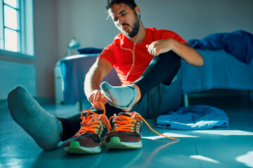 Close up of athlete tying laces on sports shoes before workout