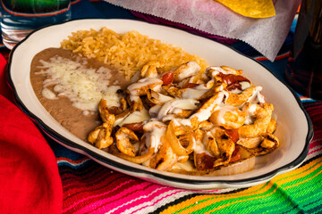 Sauteed chicken and onions with refried beans and rice