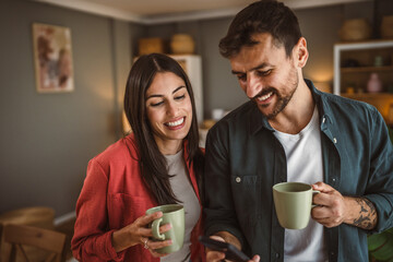 Couple use mobile phone for text message or browse internet at home