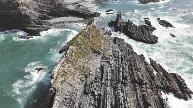 Aerial footage of rocks washed by ocean waves. Arrifana coast, west of Portugal