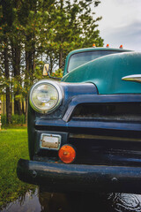 Vintage Green Truck, side view,  parked in the rain puddle yard, partial view