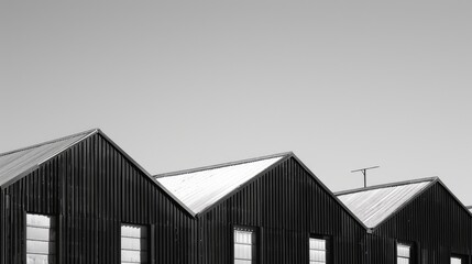 Fototapeta premium Black and white Factory Buildings with Corrugated metal roofs against blue sky