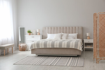 Stylish interior of contemporary bedroom with comfortable bed