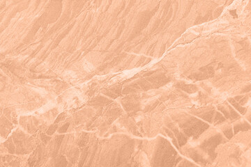 Stone surface of peach fuzz color, top view. Trendy shade of 2024 year