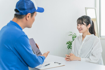 引っ越しの見積もり・移転の打ち合わせをする業者の男性
