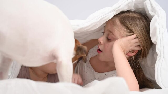 Little girl and her newborn brother hiding under the blanket.