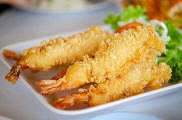 Fried Shrimp in Batter is a crispy Thai dish featuring succulent shrimp coated in a light, golden batter and deep-fried to perfection. Served with a tangy dipping sauce, it's a delightful appetizer.
