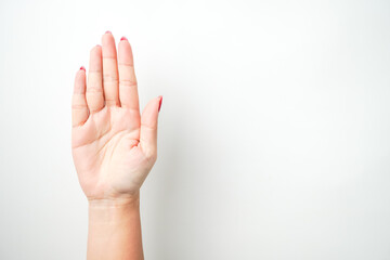 Obraz premium A woman's hand with bright red nail polish is making a raising open hand gesture. Isolated on white background - Cut Out