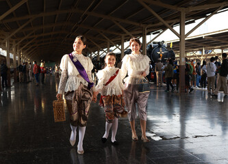Three sisters  in traditional Thai costumes having their photo taken at the train station for the retro train event in Thailand 