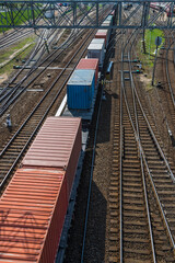 Fototapeta premium Cargo Train With Red And Blue Sea Containers. Drone View