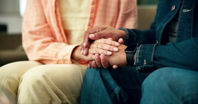 Couple, love and support with holding hands for empathy, kindness and hope or commitment on sofa at home. People or partner care with comfort for news, loss or fear with mental health in relationship