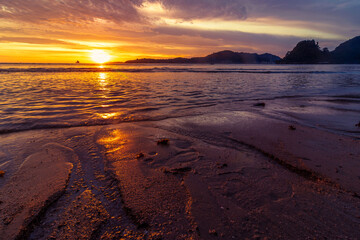 Scenic sunset scenery at beach with closeup of sand 