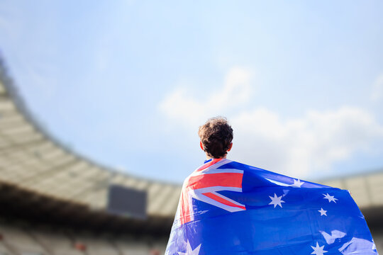 An athlete with the Australian flag draped over their shoulders, representing Australia in the stadium during a major international sporting event - Powered by Adobe
