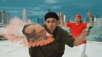 Group of multicultural hipster playing color flare at rooftop. Attractive street dancer holding...