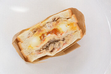 the top rotate view close-up image of the tuna sandwich with a runny egg