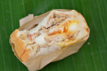 the close-up image of the tuna sandwich with a runny egg