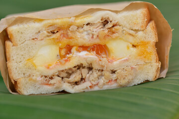 the super close-up image of the tuna sandwich with a runny egg