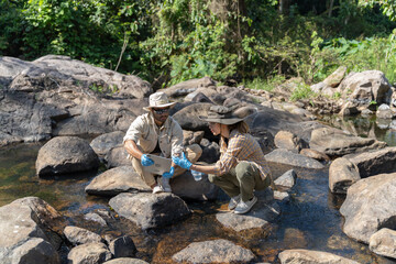water day and World environment day concept.Environmental engineers inspect water quality at natural water sources and record data on tablet.Man engineer and Woman scientist and environmental issues
