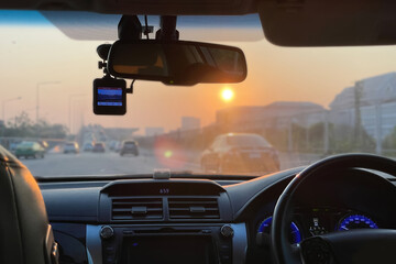 Bright and clear image interior of the car show steering wheel, dashboard, car stereo, car camera and air conditioning ventilation with traffic outside on summer morning background.