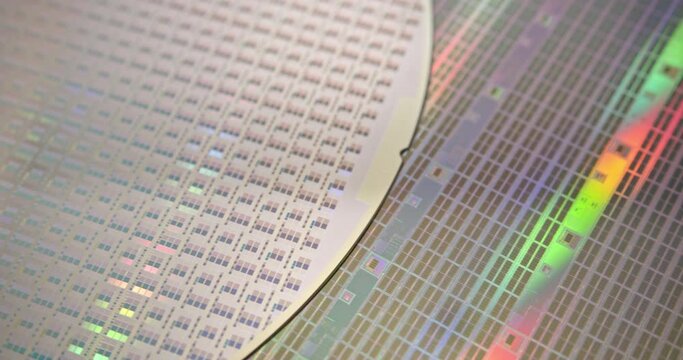 A close-up view of a silicon wafer's microprocessor circuit layout. The semiconductors or central processing unit CPU microchips are fabricated from a silicon wafer with patterned layers of materials.