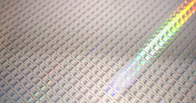 A close-up view of a silicon wafer's microprocessor circuit layout. The semiconductors or central processing unit CPU microchips are fabricated from a silicon wafer with patterned layers of materials.