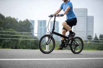 Riding a fold bike with modern city in the distrance