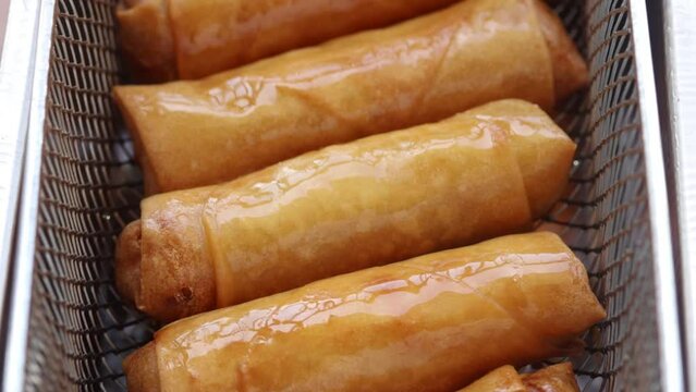 Deep Frying Spring Roll in Deep Fryer Basket and Lift Them Out of The Boiling Oil. Chinese food