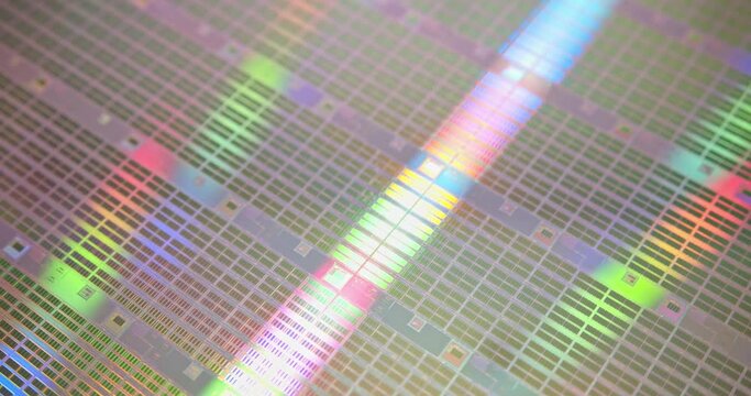 A close-up view of a silicon wafer's microprocessor circuit layout. The semiconductors or central processing unit CPU microchips are fabricated from a silicon wafer with patterned layers of materials.