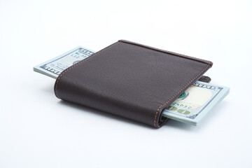 A stack of US dollars flanking in a leather wallet isolated on white background