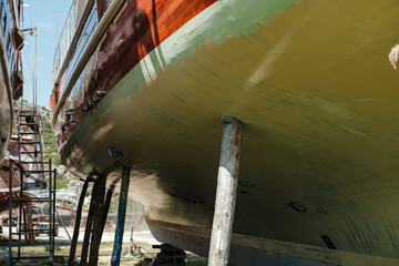 wooden gulet boat hull in dry dock maitenance ready for paint, maintenance of yacht © Ela