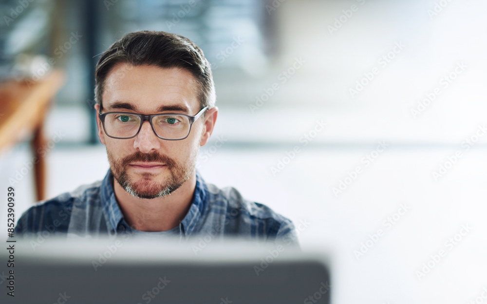 Aufkleber Man, glasses and computer in office for review, typing and research in workplace. Businessman, startup and reading at desk for communication, thinking and networking or feedback with technology
