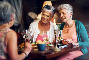 Senior women, friends and lunch in restaurant for wine, vacation and retirement together with happy. Elderly people, reunion and relax in diner for drinks, food and social celebration with memory