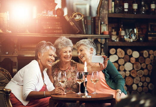 Senior women, friends and selfie in restaurant for wine, vacation and retirement together with happiness. Elderly people, reunion and memory in diner for drinks, holiday and birthday celebration