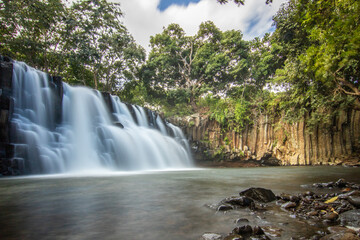 The waterfall is a 10 m high waterfall that cascades over basal steles into a pool. Tropical nature and landscape at Rochester Falls, Mauritius.