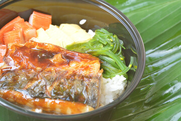 the close-up image of the Japanese dish featuring grilled Norwegian mackerel (saba) on rice left view