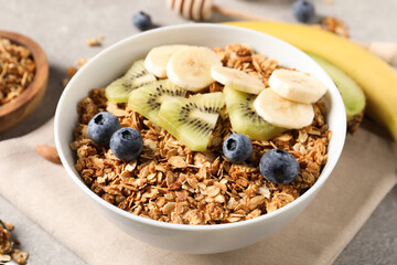 Tasty granola with fresh fruits on grey table, closeup
