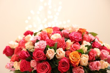 Beautiful bouquet of colorful roses on beige background